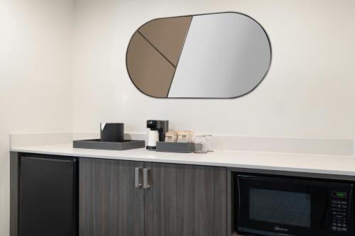 a mirror on the wall above a microwave at Courtyard by Marriott across Universal Orlando in Orlando