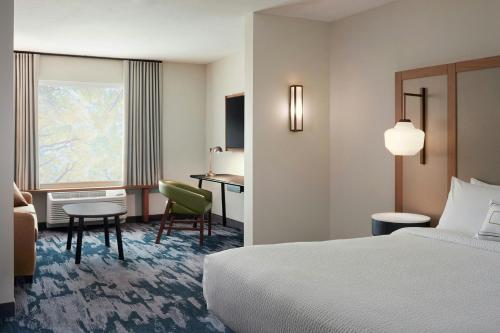 a hotel room with a bed and a desk at Fairfield by Marriott Inn & Suites Matteson Chicago in Matteson