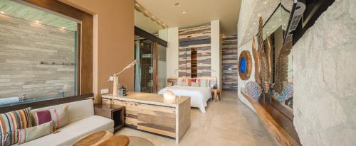 a living room with a couch and a mirror at La Casa de la Playa by Xcaret- All Inclusive Adults Only in Playa del Carmen