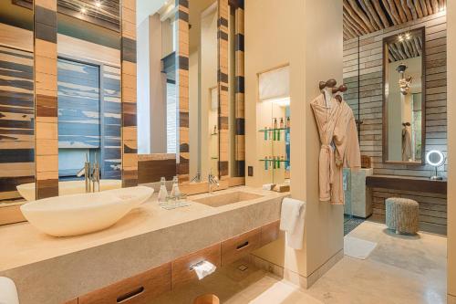 a bathroom with a large sink and a large mirror at La Casa de la Playa by Xcaret- All Inclusive Adults Only in Playa del Carmen