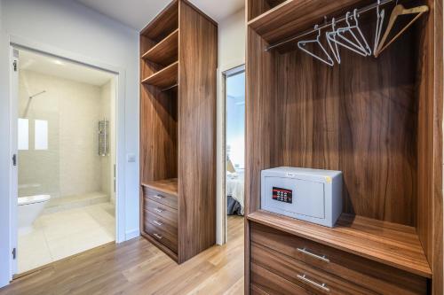 a bathroom with a large wooden closet with a television in it at Agora Boutique Coliving Madrid in Madrid