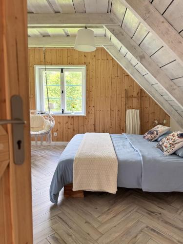 a bedroom with a bed in a wooden room at Chata na Zielonym Wzgórzu in Garcz