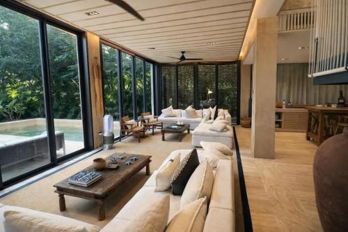 a large living room with white furniture and large windows at Luxury Villa in Corasol 4BR Private Pool in Playa del Carmen