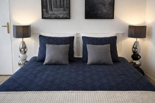 a bedroom with a blue bed with two lamps at Tribunal du Beffroi in Douai