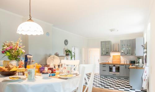 a kitchen with a table with food on it at Elbferienhaus Lenzerwische - gemeinsames Urlauben an der Elbe mit privaten Badesee - alles inklusive in Lenzerwische