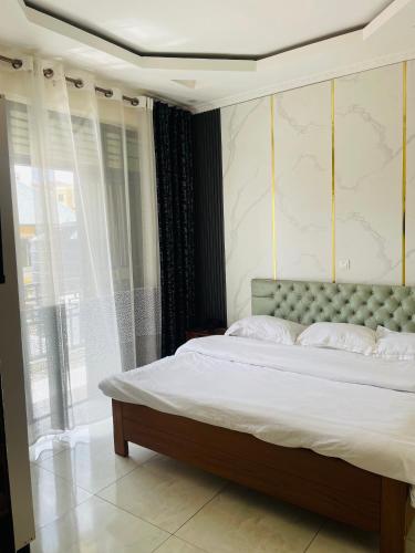 a bedroom with a bed and a large window at Kigali Sky Light Homes in Kigali