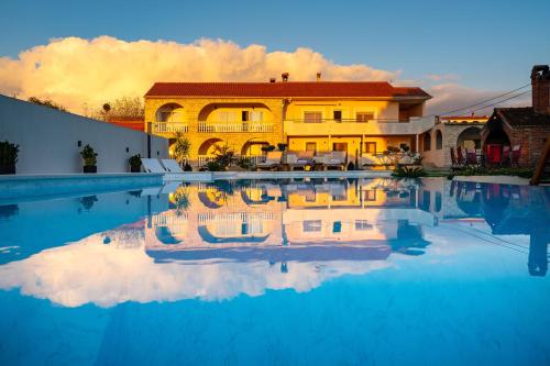 a house with a reflection in a swimming pool at My Dalmatia - Apartment M&N with shared pool in Galovac