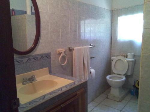 a bathroom with a sink and a toilet and a mirror at Reach For The Islands in Corn Islands