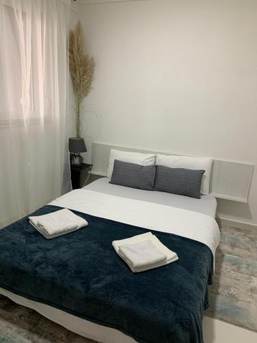a bedroom with a large bed with two towels on it at Aura in Kumanovo