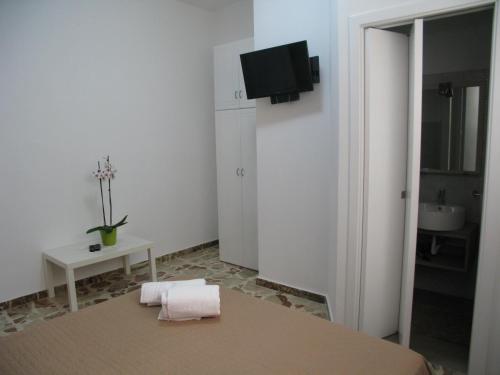a white room with a table and a tv on the wall at La Casa Dei Nonni in Custonaci