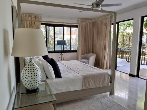 a bedroom with a bed and a table with a lamp at Beachfront Portillo Residence in Las Terrenas