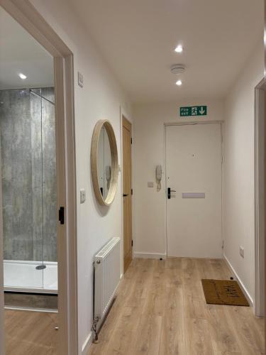 a hallway with a bathroom with a tub and a mirror at 7 min from Edinburgh Airport 2 Bedroom Apartment in Edinburgh