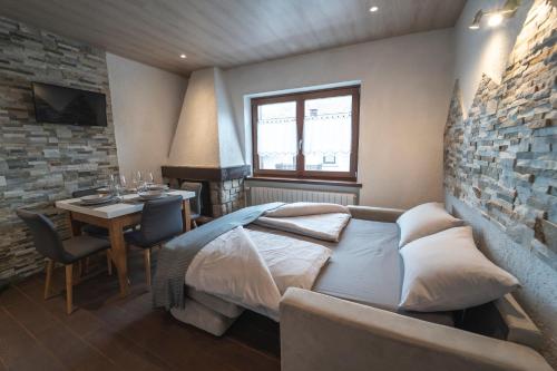 a bedroom with a bed and a table and a dining room at Baita PierGi in Livigno