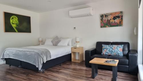 a bedroom with a bed and a couch and a table at Mt Field Retreat in National Park