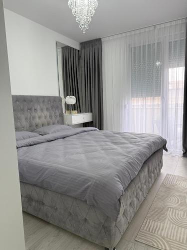 a bedroom with a large bed and a chandelier at Apartman welsh in Bugojno