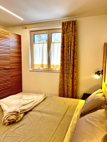 a bedroom with two beds and a window at Nos Sweet Home in Dimaro