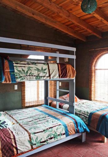 two bunk beds in a room with two windows at Eco ITZKA Bernal Country House in Bernal