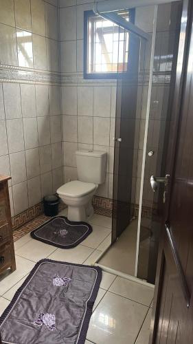 a bathroom with a toilet and a glass door at Casa do Igra in Torres