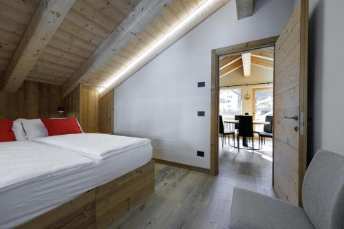 a bedroom with a bed and a dining room at Chalet Boscopiano in Valdidentro