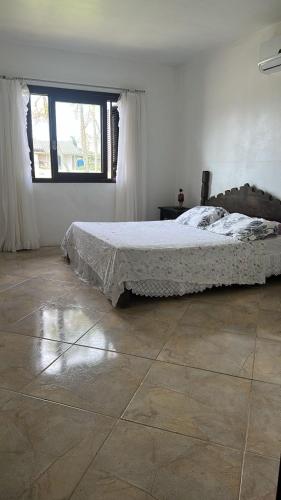 a bedroom with a bed and a large window at Casa do Igra in Torres