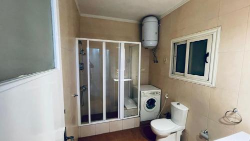 a bathroom with a toilet and a washing machine at Stay Ra3 Suites in Cairo