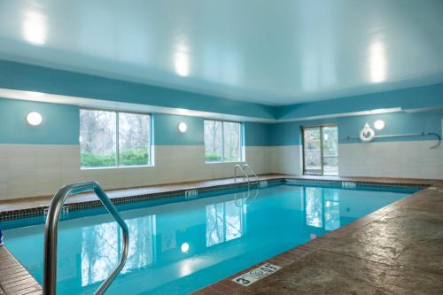 a swimming pool with blue walls and windows at Holiday Inn Express Hotel & Suites Memphis/Germantown by IHG in Memphis