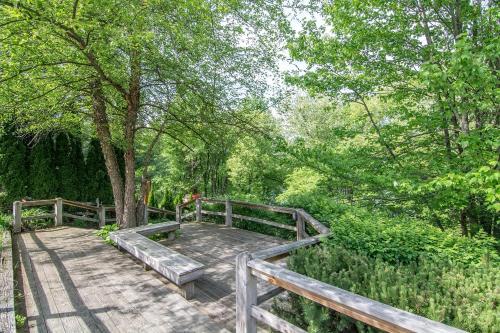 a wooden boardwalk in a park with trees at Lake & Lift by Railey Vacations in McHenry