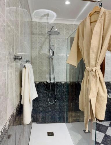 a bathroom with a shower with towels on a rack at Island View Retreat in Feteira