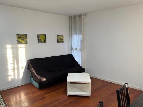 a bedroom with a black bed and a table at Habitaciones Carmen in Rubí