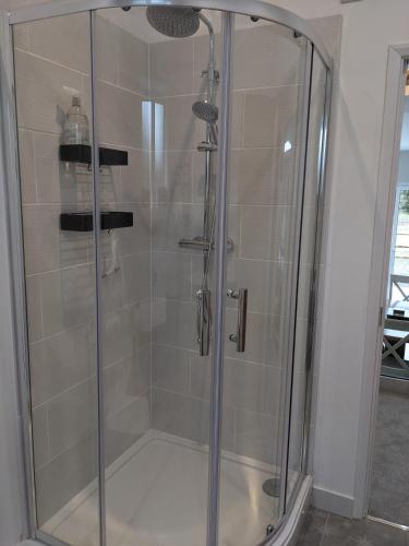 a shower with a glass door in a bathroom at The Roost at The Gables Farm in Poynton