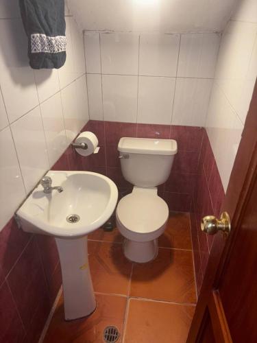 a small bathroom with a toilet and a sink at Triple B in Loja