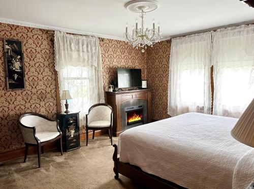 a bedroom with a bed and a fireplace and a tv at The Ginkgo Tree in Mount Pleasant