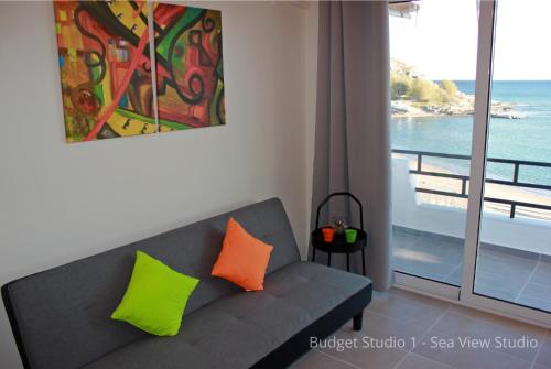a living room with a couch and a view of the ocean at Budget Studios Haraki in Haraki