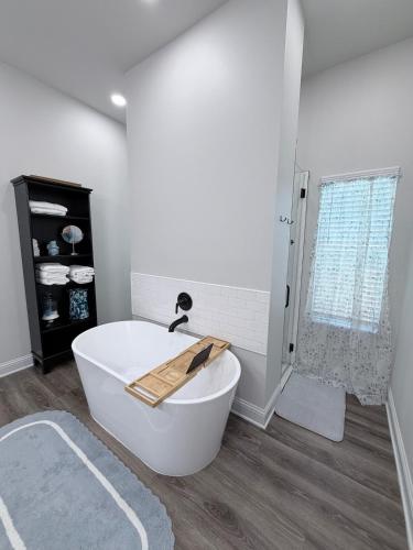 a white bath tub in a bathroom with a shower at Wanderlust House in Shreveport