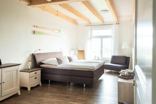 a bedroom with a bed and a chair in it at Gut-Royum-Strohlager in Brodersby