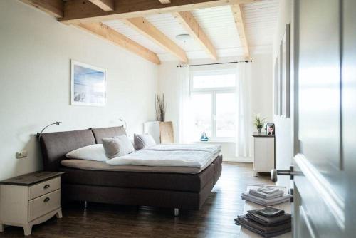 a bedroom with a bed and a large window at Gut-Royum-Haferkiste in Brodersby