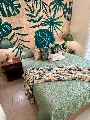 a bedroom with a green bed with a wall at Casa Familiar en La Paz BCS in La Paz