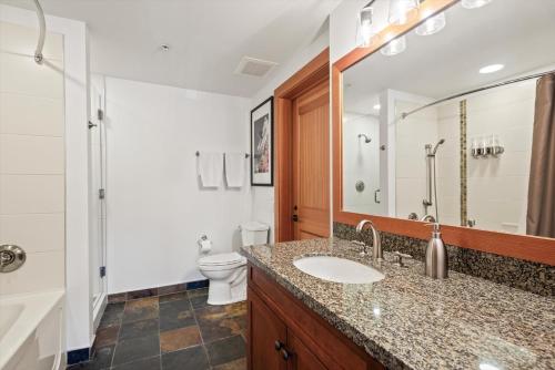 a bathroom with a sink and a toilet and a mirror at The Powder Post Capitol Peak Lodge #3225 in Snowmass Village