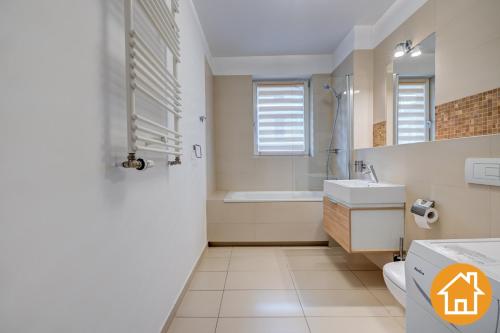 a bathroom with a toilet and a sink and a shower at Apartamenty Tulip - visitopl in Międzyzdroje