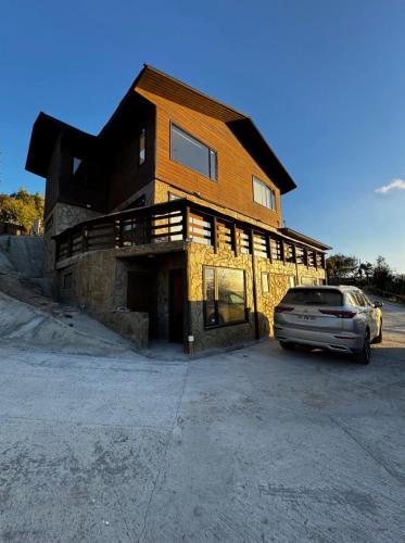 a house with a car parked in front of it at Casa Hotel Los Arrayanes in Constitución