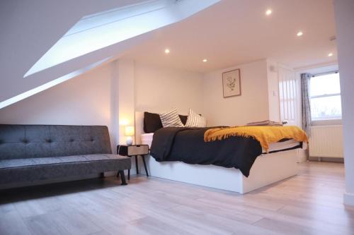 a bedroom with a bed and a couch at 96 Nelgarde Guesthouse in London