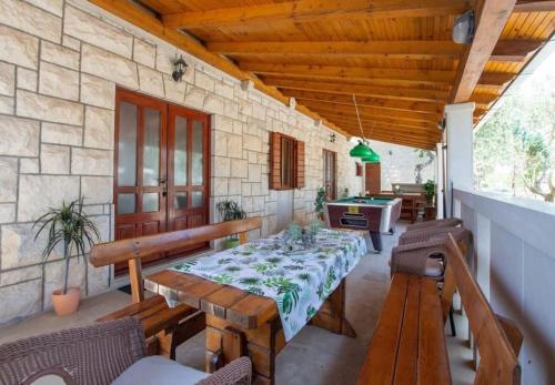 a patio with a table and benches and a pool table at House Niksi in Škrip