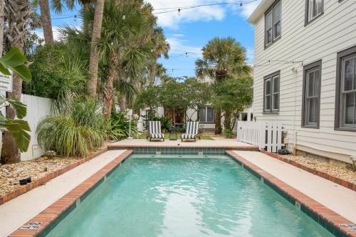 a swimming pool in a yard next to a house at Be A Nomad - Pool Access Studio Apartment - Jacksonville Beach Couples in Jacksonville Beach