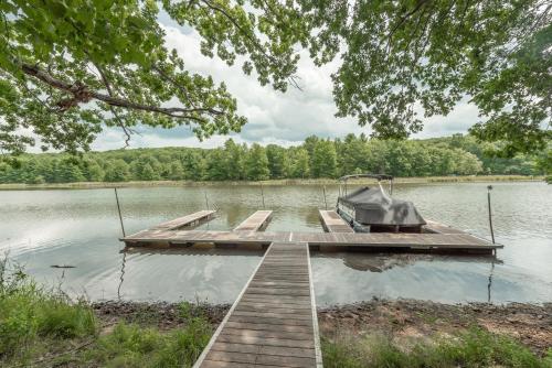 a dock with a boat on a lake at Lakefront Escape by Railey Vacations in Swanton