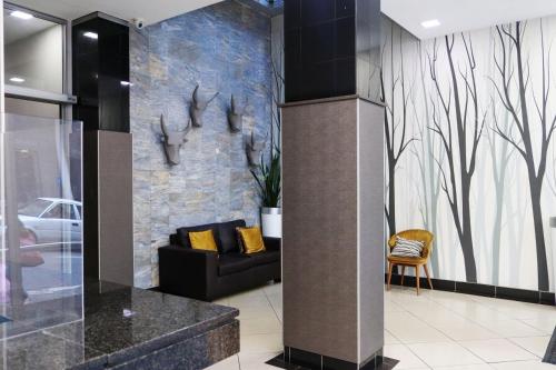 a lobby with a couch and a wall with antlers at The Orange Corner II in Johannesburg