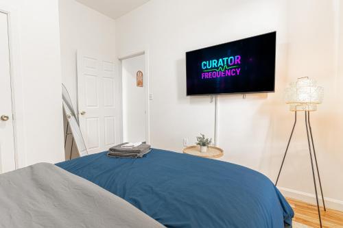 a bedroom with a bed and a tv on the wall at Comfy 2B Near LGA & Subway with Washer & Dryer in Corona