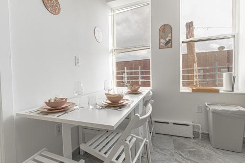 a white kitchen with a table and chairs and a window at Comfy 2B Near LGA & Subway with Washer & Dryer in Corona