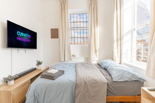 a bedroom with a bed and a tv on a wall at Comfy 2B Near LGA & Subway with Washer & Dryer in Corona