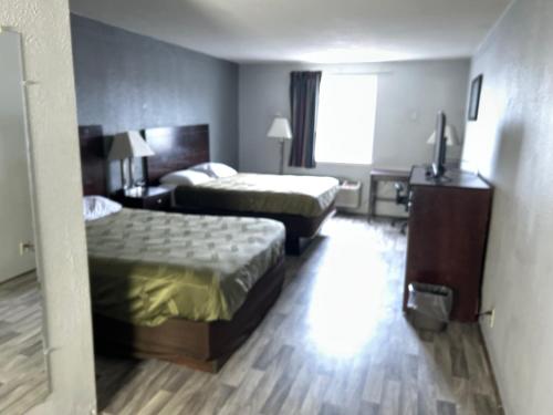 a hotel room with two beds and a desk at Economy Inn of Reading in Reading
