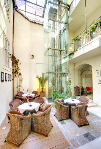 restauracja z wiklinowymi krzesłami i stołami w budynku w obiekcie Three Storks w Pradze